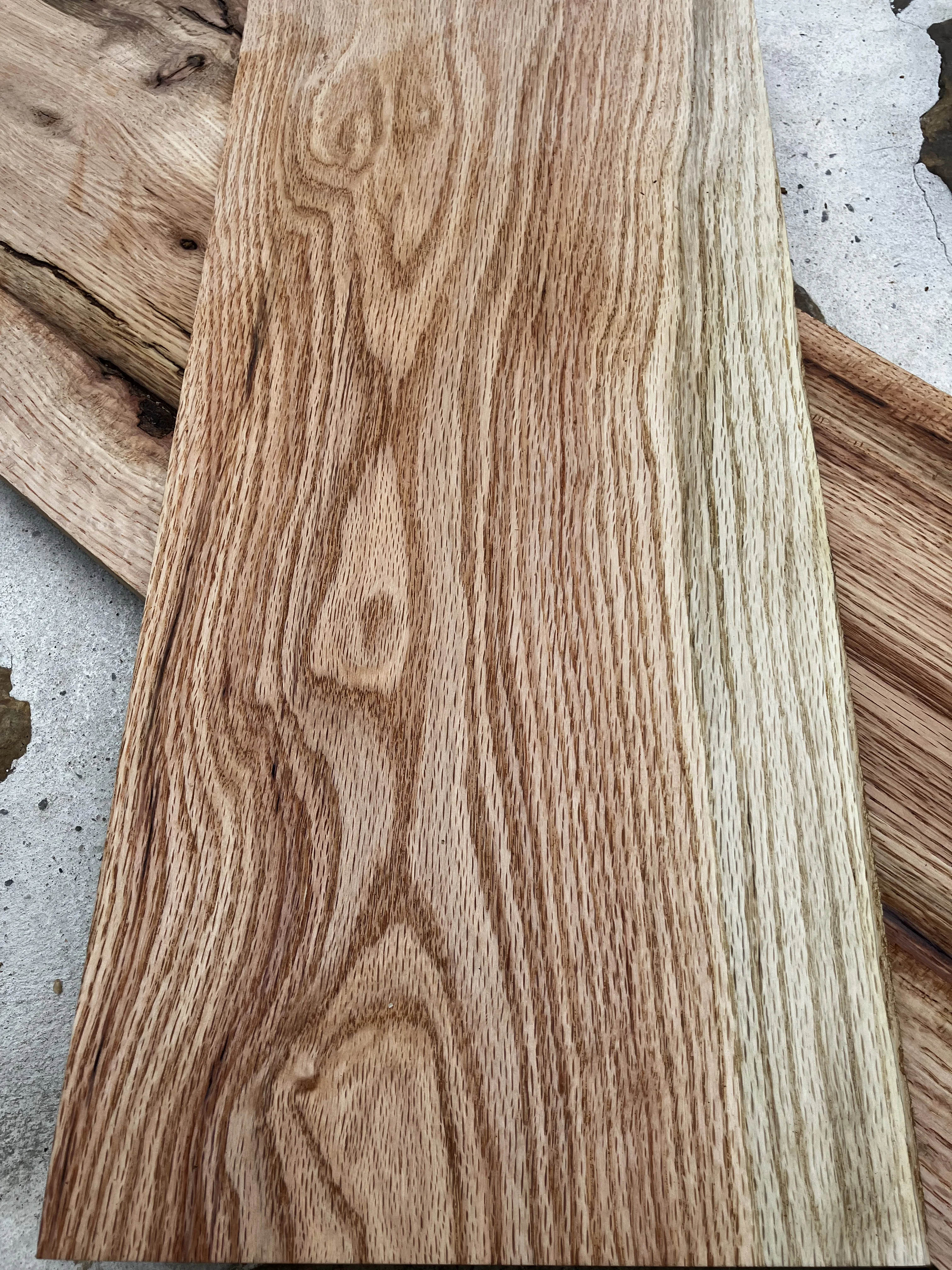 Red oak wood grain — warm reddish-brown tones with a bold, open grain pattern, harvested in Tennessee